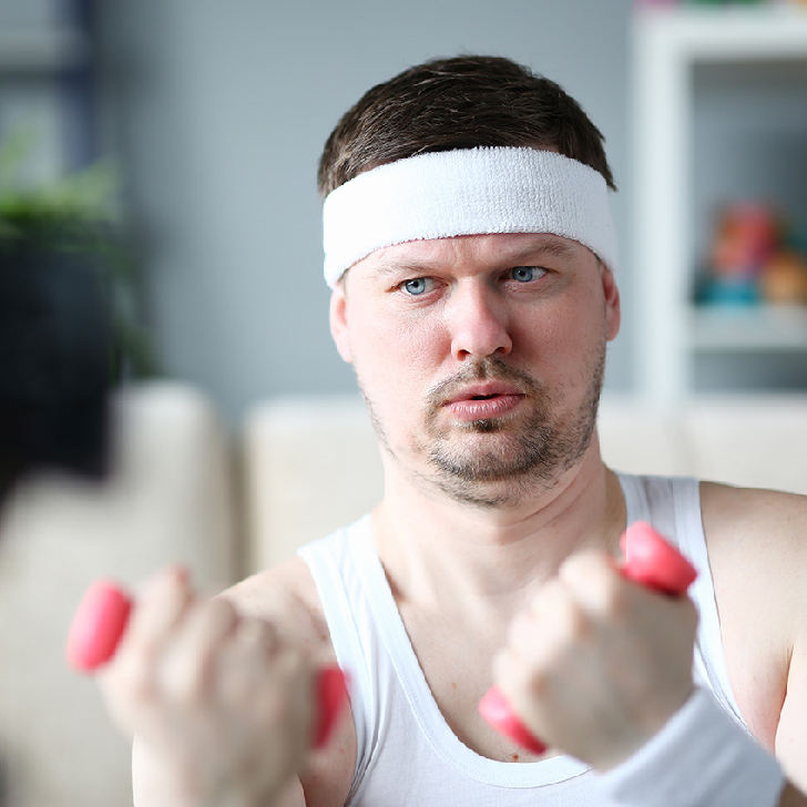 Harry Smith wearing a handband and lifting comically small pink weights